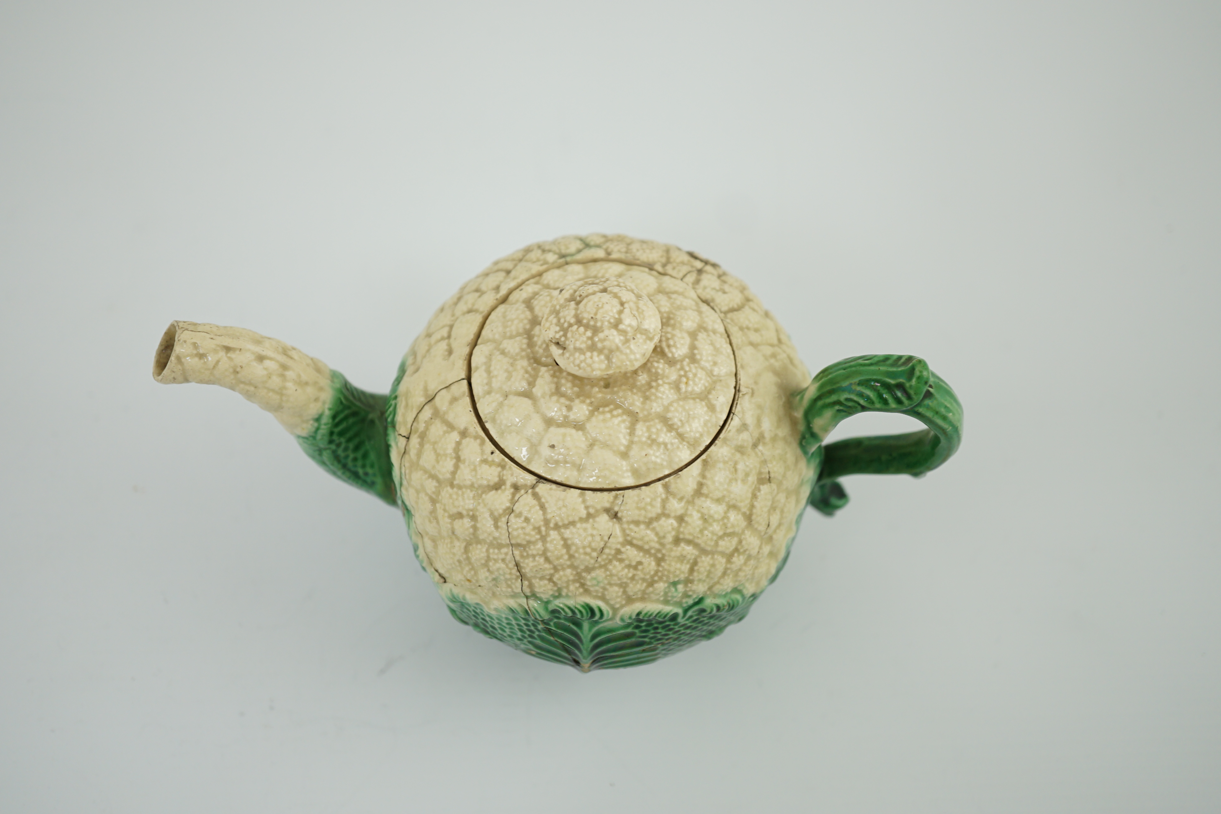 A Staffordshire cauliflower shaped creamware teapot and cover, c.1770, 10. 5 cm high. Condition - broken and repaired